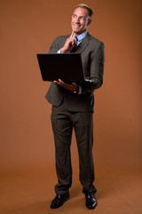 Wall Mural - Full body shot of businessman using laptop computer