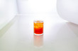glass of red alcohol with ice on white background