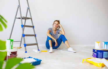 Wall Mural - Repair in apartment. Happy young woman paints wall .