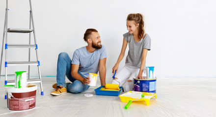 Wall Mural - young happy couple is repairing and painting   wall at home.