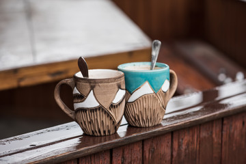 two coffee cups on wet wooden surface, morning rainy autumn