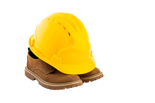Fototapete - Yellow safety helmet and a pair of shoes on whte background