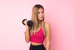 © luismolinero - Young sport blonde woman over isolated pink background making weightlifting with kettlebell