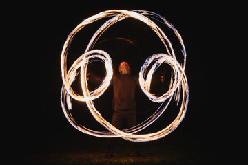 Fire spinner making different figures with fire. Slow motion image