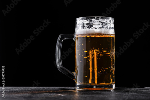 Cuadros en Lienzo Glass mug filled with fresh beer with foam against black background