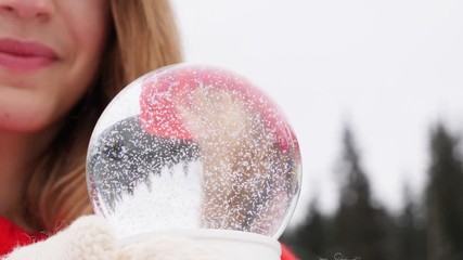 Poster - Young woman holding snow globe outdoors, closeup. Winter vacation