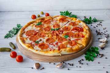 Italian pizza pepperoni on a light wooden background