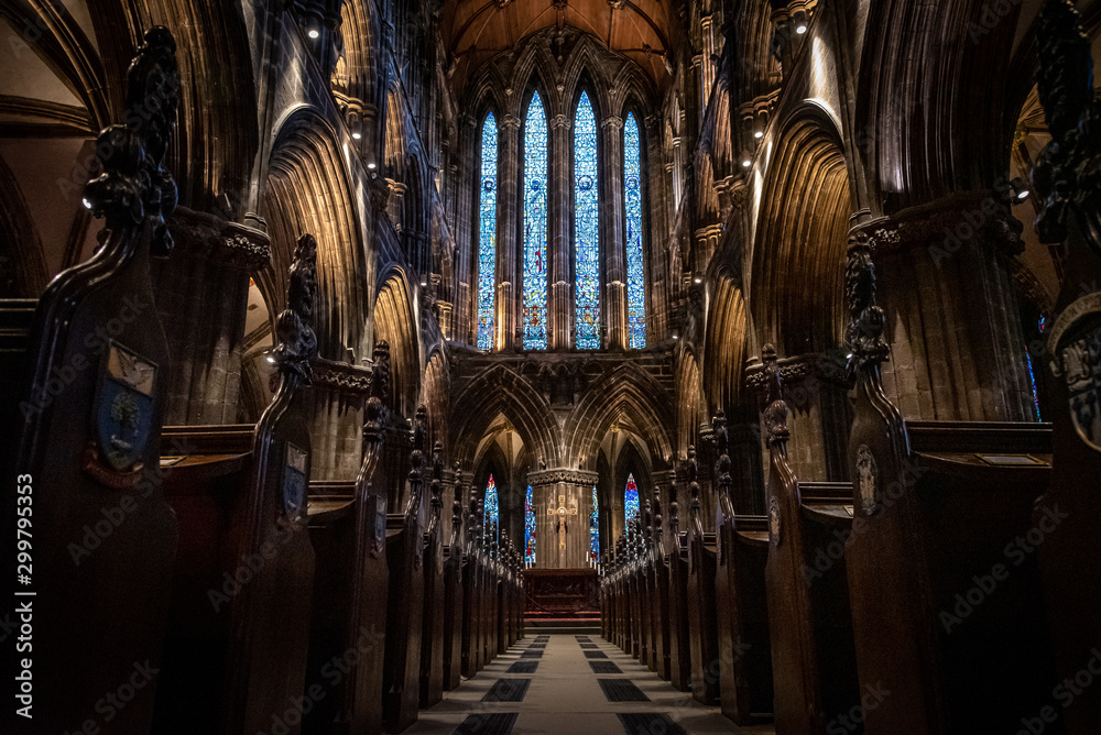 GLASGOW, SCOTLAND, DECEMBER 16, 2018: Magnificent perspective view of interiors of Glasgow Cathedral, known as High Kirk or St. Mungo, with huge stained glasses. Scottish Gothic architecture. - obrazy, fototapety, plakaty 
