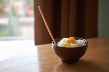 Wall Mural - Japanese traditional rice tamago kake gohan with raw egg in bowl on wooden table