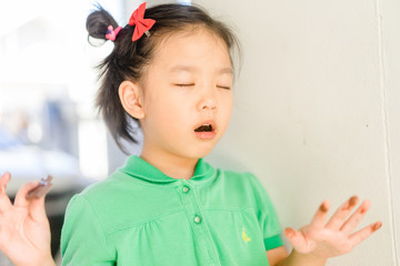 Wall Mural - 4 years old little asian girl eating chocolate bar.Close up face a happy child girl who has eaten chocolate remembers how delicious she was.