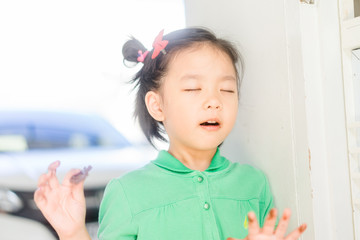 Wall Mural - 4 years old little asian girl eating chocolate bar.Close up face a happy child girl who has eaten chocolate remembers how delicious she was.