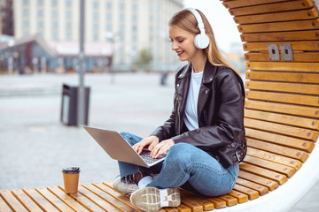 Wall Mural - Modern woman using her laptop on the bench