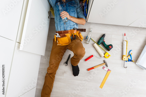 Fotomural drunk plumber doing sink reparation