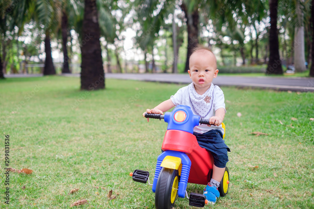 Cute little Asian 1 year old toddler baby boy child riding his tricycle ...