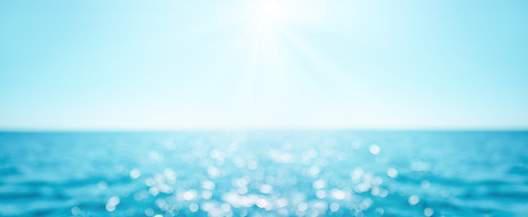 beautiful blur defocused blue sea background with sun rays and bokeh. landscape of tropical summer. 