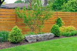 An Asian inspired and beautifully maintained garden features rockery and minimalist style cedar fencing.