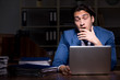 © Elnur - Young male employee working night in the office