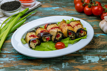 Wall Mural - Eggplant rolls stuffed with nuts on wooden table