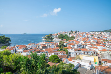 Canvas Print - Orange roof tops and whitwashed walls of Skiathos town from top of hill with church of Saint Nikolaos