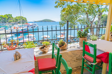 Sticker - Green chairs with red cushions and tables at a balcony cafe