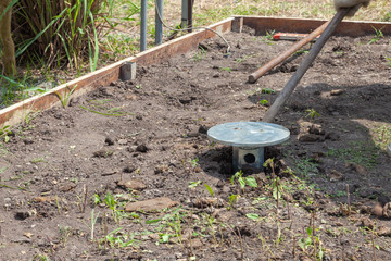 Worker manual drilling hole on the ground at sunny day