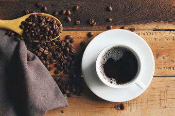 cup of coffee and beans on wooden table