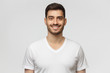 © Damir Khabirov - Portrait of smiling handsome young man in white t-shirt, looking at camera, isolated on gray background