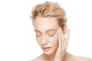 young woman holding collagen eye patch with one hand, isollated on white background. perfect clean f