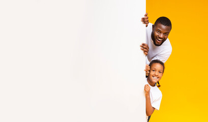 Wall Mural - Black Father And Daughter Peeking Out Of White Advertisement Board