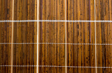 Wall Mural - Old wooden sun-bleached blinds on the window. The morning sun shines through the blinds consisting of wooden slats and planks