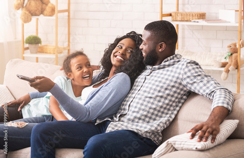 Fotomural Joyful family having fun together, relaxing on sofa at home
