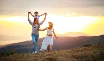 Happy family father of mother and child son  on nature at sunset.