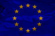 © kittyfly - close-up photo of beautiful colored stylized European Union flag, symbol of united Europe on textured fabric, concept of tourism, emigration, economy and politics, close-up