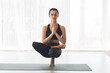 Woman practising yoga at home, sitting on tiptoe