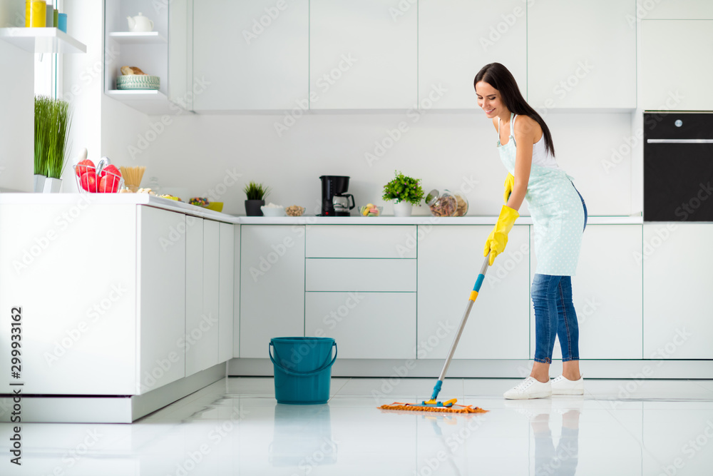 Profile side full size photo of positive cheerful girl having mop washing floor wearing white singlet yellow rubber gloves dotted apron fell content enjoy household chores in kitchen house indoors - obrazy, fototapety, plakaty 