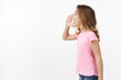 Profile shot cute lovely blond young girl, child calling friend hold hand near opened mouth shouting name, searching parent smiling joyfully, playing hide-n-seek on playground, stand white background