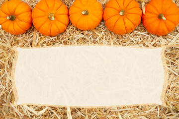 beige straw hay background with pumpkins