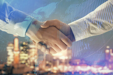 Double exposure of world map on cityscape background with two businessmen handshake. Concept of international business