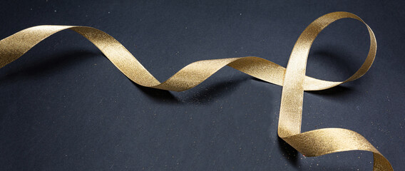 golden satin ribbon on black background, banner
