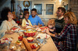 © luckybusiness - Family and friends dining at home celebrating christmas eve with traditional food