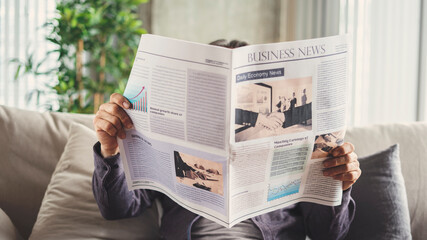 Senior man reading newspaper at home