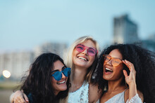 Three Beautiful Women With Colorful Sunglasses Standing At Evening Outdoors
