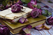 Withered Roses With Vintage Letters Close-up. Faded Flowers, Old Letters On A Wooden Table. Vintage Beautiful Photo OfNostalgic Vintage Mood Background. Dry Decorative Purple Rosebuds And Old Letters.