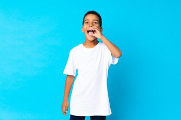 African American boy over isolated blue background shouting with mouth wide open