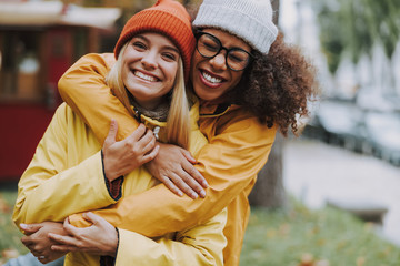 Two young females hugging and smiling wide