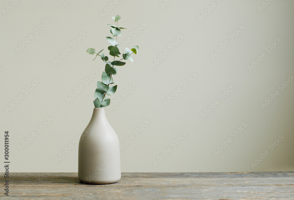 Eucalyptus branch in a vase on the table with copy space - obrazy, fototapety, plakaty 