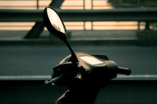 Motorcycle Scooter.scooter With Headlight, Handlebar And Mirrors Against Blue Sky. Against The Background Of The Setting Sun