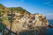 Village Manarola with road sign in the foreground during summer time in Cinq Terre, Italy