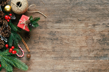 Wood texture decorate with pine leaves, pine cones, holly balls, gift box and candy cane in Christmas concept. Vintage wooden background in top view flat lay with copy space for Christmas wallpaper.