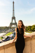 © Wedding photography - Paris fashion. Woman in black dress posing near Eiffel tower